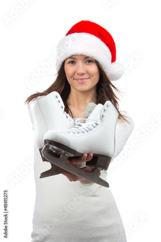 Photo: Woman showing ice skates in christmas santa hat smiling Woman showing ice skates in christmas santa hat smiling