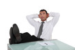 Businessman resting feet on desk