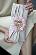 Model holding designer clutch decorated with flower