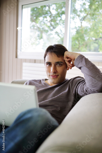 Photo: Young man on a sofa with a laptop Young man on a sofa with a laptop