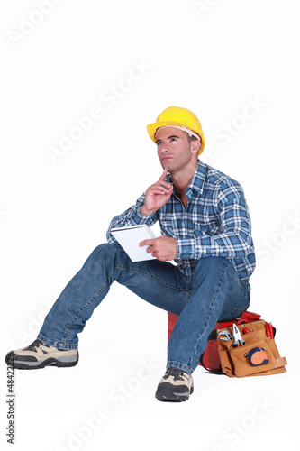Photo: Builder sat on tool box thinking Builder sat on tool box thinking