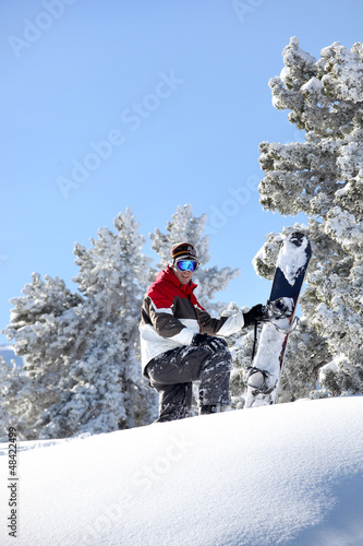 Photo: Man stood at the top of mountain with snowboard Man stood at the top of mountain with snowboard