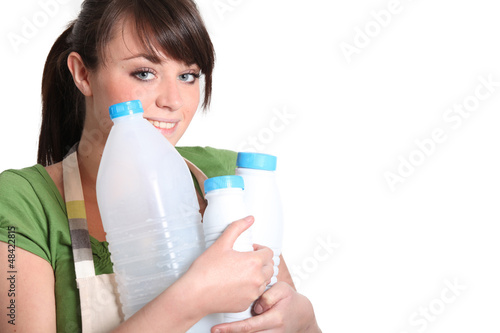 Photo: young woman carrying empty bottles of milk young woman carrying empty bottles of milk