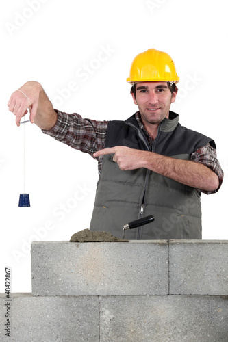 Photo: Bricklayer checking that wall is level Bricklayer checking that wall is level