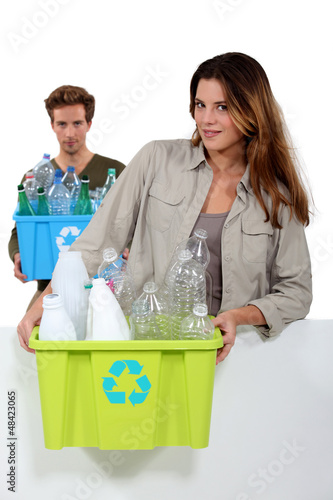 Photo: Young couple carrying plastic bottles Young couple carrying plastic bottles