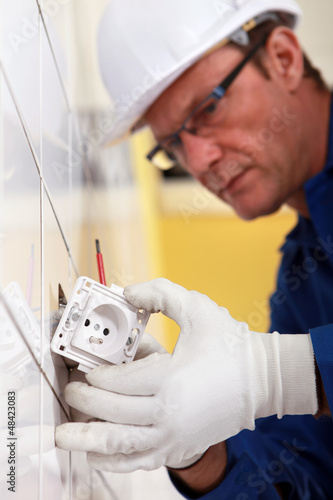 Photo: Electrician fitting electrical outlet Electrician fitting electrical outlet