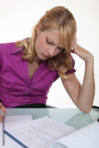 Photo: Woman filling in paperwork Woman filling in paperwork
