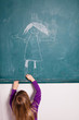 Young girl drawing on chalkboard
