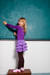 Young girl drawing on chalkboard