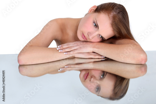 Photo: Woman resting head on reflective surface Woman resting head on reflective surface