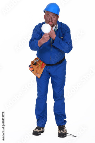 Photo: Inexperienced electrician with bulb Inexperienced electrician with bulb