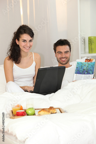 Photo: Couple in bed with a laptop Couple in bed with a laptop