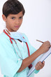 Little boy with chart dressed-up as doctor