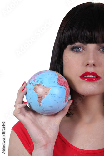Photo: Serious beautiful woman with the world in her hand Serious beautiful woman with the world in her hand