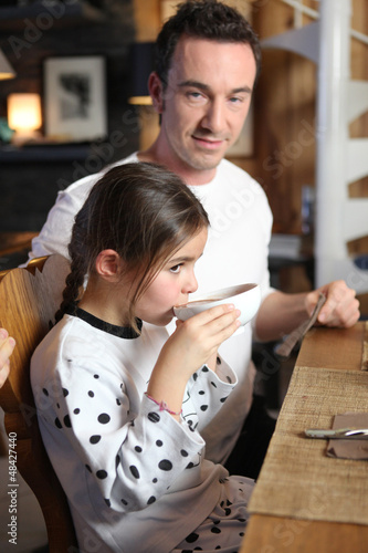 Photo: Girl drinking hot chocolate with her father Girl drinking hot chocolate with her father