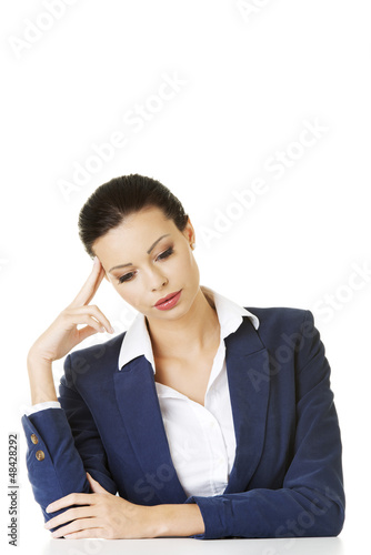 Photo: Sad businesswoman sitting behind the desk Sad businesswoman sitting behind the desk