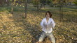 A young woman throws yellow leaves in autumn park