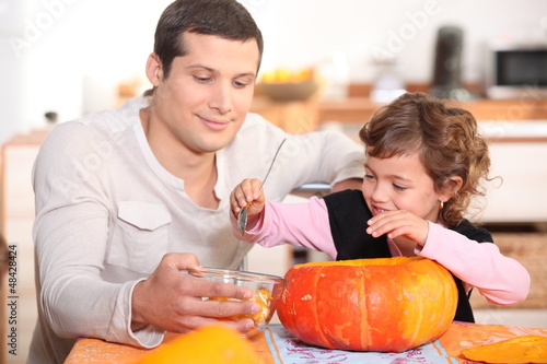 Photo: Dad and daughter hollowing out a pumpkin Dad and daughter hollowing out a pumpkin