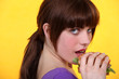 Young brown-haired woman eating a hamburger