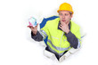 Pensive builder holding globe