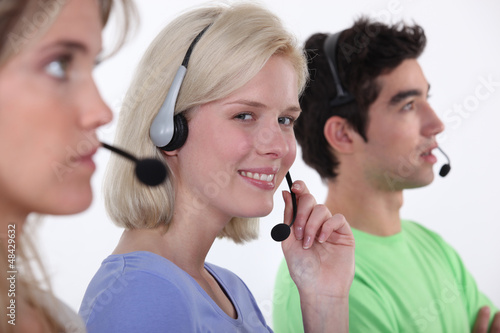 Photo: Three call-center workers sat in a row Three call-center workers sat in a row