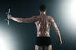 Photo: Back of young male bodybuilder doing weight exercise Back of young male bodybuilder doing weight exercise