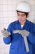 Young plumber with plastic pipe