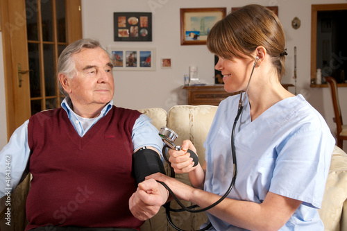 Photo: Pflegekraft misst Blutdruck bei Senior Pflegekraft misst Blutdruck bei Senior