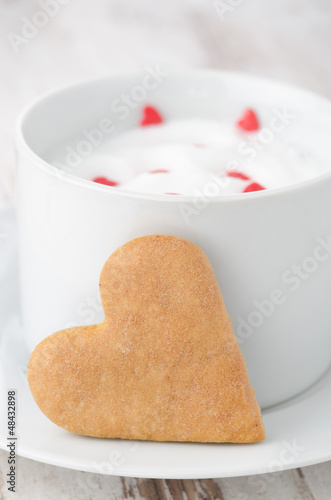 Photo: cup of hot milk with foam, decorated with sugar hearts and heart cup of hot milk with foam, decorated with sugar hearts and heart