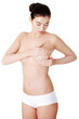 Woman examining breast mastopathy or cancer.