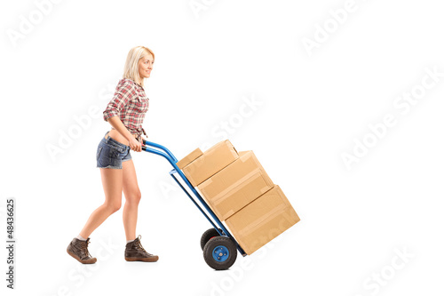 Photo: Female worker pushing a hand truck with boxes Female worker pushing a hand truck with boxes