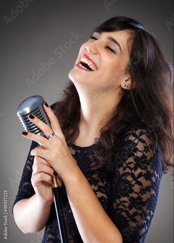 Photo: Attractive young woman with a retro microphone Attractive young woman with a retro microphone