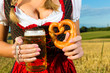 Weiblicher Körper ohne Kopf mit Bier und Brezel