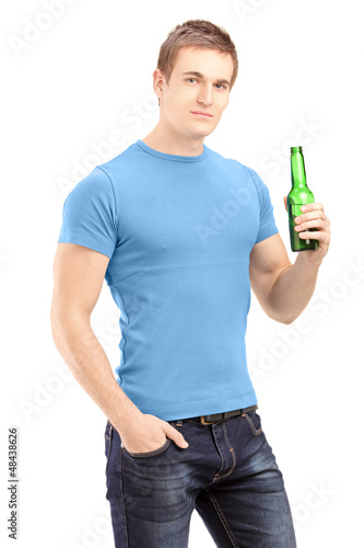 Photo: Young handsome man holding a bottle of beer Young handsome man holding a bottle of beer