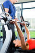Trainer und Frau im Fitnessstudio