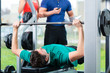 Trainer und Mann im Fitnessstudio