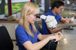 Technician working on dental prosthesis under a microscope
