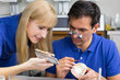 Two dental technicians choosing the right colour for dental porc