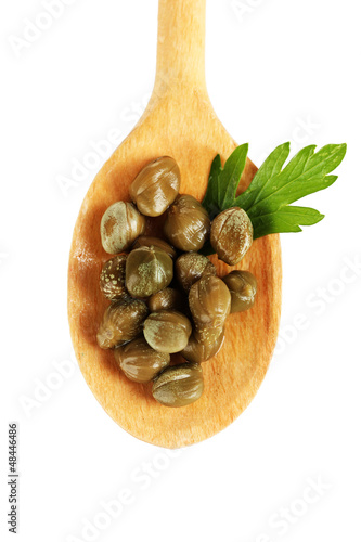 Photo: green capers in wooden spoon on white background close-up green capers in wooden spoon on white background close-up