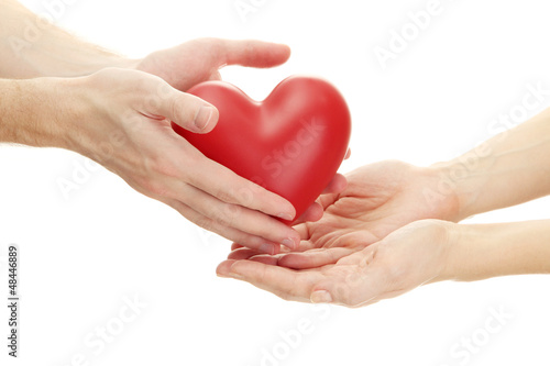 Photo: Red heart in woman and man hands, isolated on white Red heart in woman and man hands, isolated on white