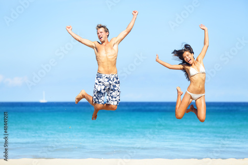 Photo: Beach people - happy couple jumping Beach people - happy couple jumping