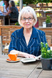 Seniorin im Cafe