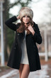Photo: young woman wearing coat walking down the street, cold winter young woman wearing coat walking down the street, cold winter