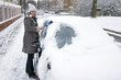 Photo: Woman remove snow from windshield Woman remove snow from windshield
