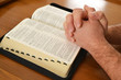 Man praying over a Bible