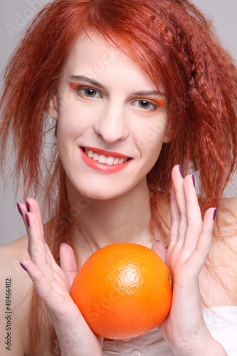 Photo: portrait of redhaired woman with orange portrait of redhaired woman with orange