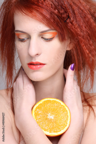 Photo: portrait of redhaired woman with orange half portrait of redhaired woman with orange half