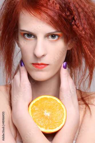 Photo: close up portrait of redhaired woman with orange half close up portrait of redhaired woman with orange half