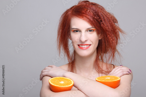 Photo: smiling redhaired woman with orange half smiling redhaired woman with orange half