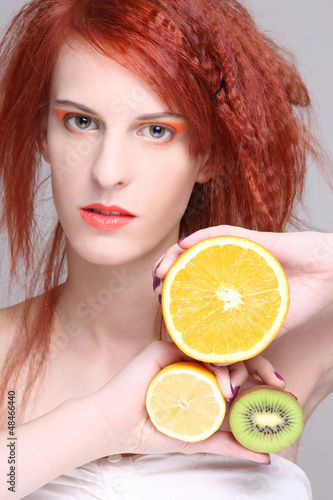 Photo: redhaired woman with orange, lemon and kiwi redhaired woman with orange, lemon and kiwi